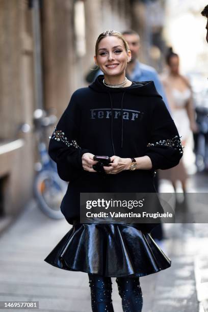 Olivia Palermo is seen wearing a Ferrari black hoodie, leather pleated mini skirt and black boots outside the Ferrari show during the Milan Fashion...