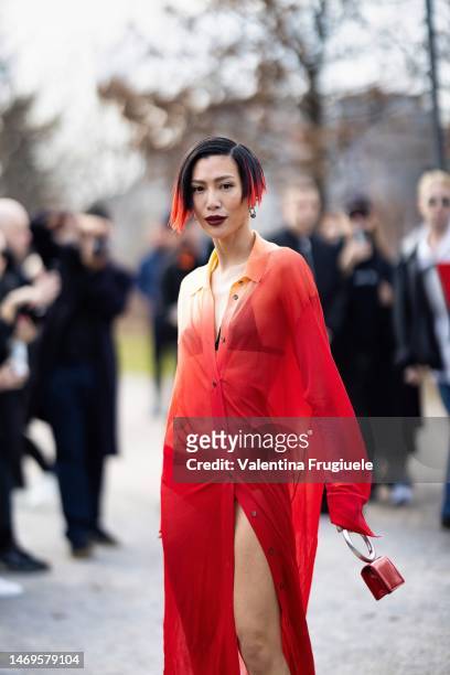 Molly Chiang is seen wearing a long see-through red tulle button shirt, a black bra, panties and a mini bag outside the Ferragamo show during the...