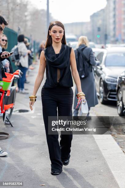 Rania Fawaz wears black wrapped top, outside Ferragamo during the Milan Fashion Week Womenswear Fall/Winter 2023/2024 on February 25, 2023 in Milan,...