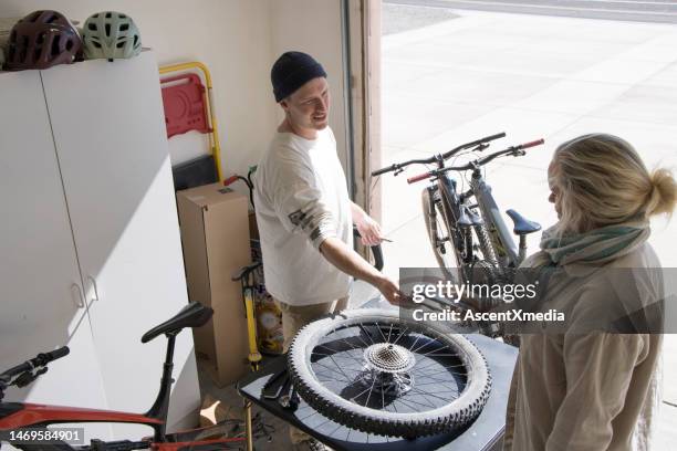 female client pays bike rental/repair shop owner for maintenance done on her ebike - receiving feedback stock pictures, royalty-free photos & images