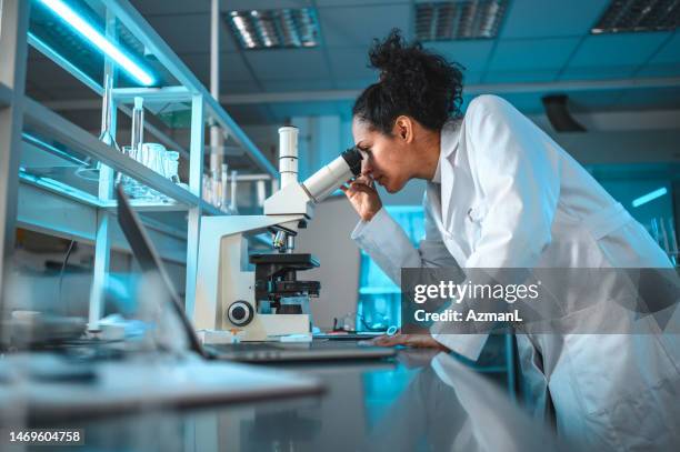young female medical worker analyzing results - biochemist stock pictures, royalty-free photos & images