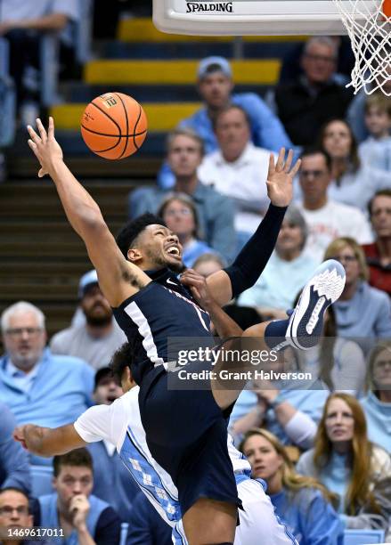 Jayden Gardner of the Virginia Cavaliers crashes into Puff Johnson of the North Carolina Tar Heels as they battle for a rebound during the second...