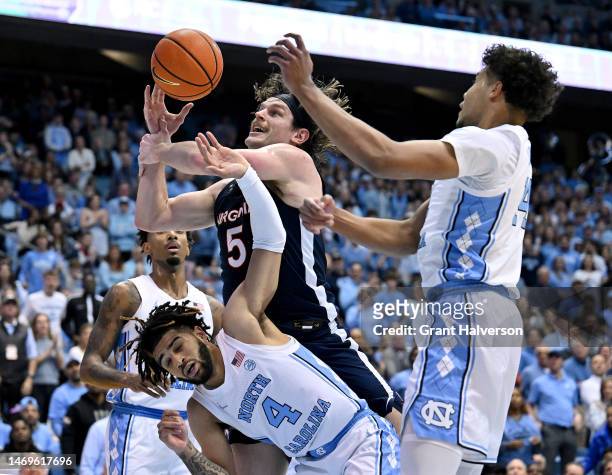 Ben Vander Plas of the Virginia Cavaliers drives to the basket against R.J. Davis and Puff Johnson of the North Carolina Tar Heels during the first...