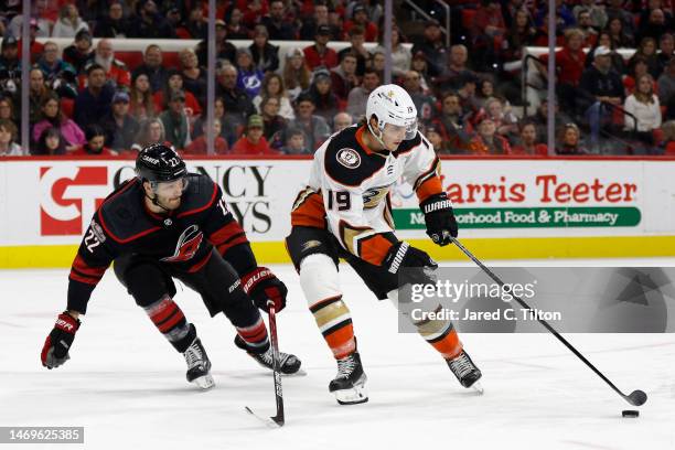 Troy Terry of the Anaheim Ducks protects the puck from Brett Pesce of the Carolina Hurricanes during the third period of the game at PNC Arena on...