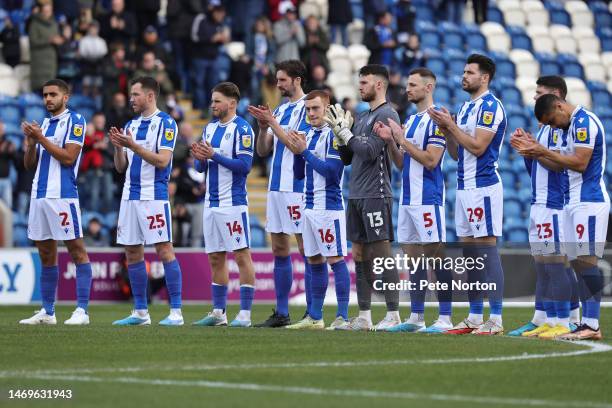 Colchester United players observe a minutes applause as a show of Solidarity on the one year anniversary of the conflict in Ukraine prior to the Sky...