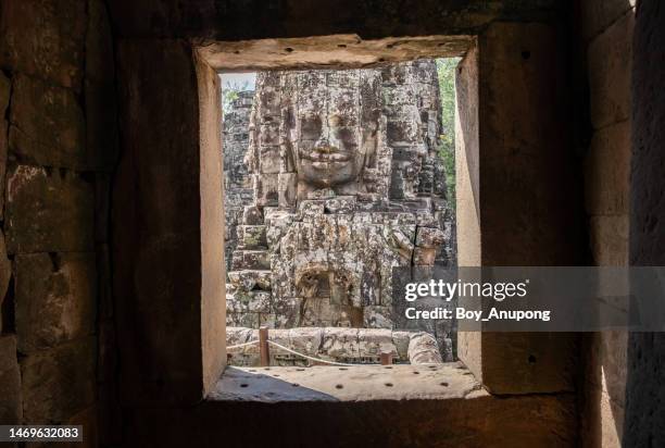 the mystery face tower in bayon temple the state temple of the mahayana buddhist king jayavarman vii in siem reap, cambodia. view from the inside of bayon sanctuary. - bayontempel stockfoto's en -beelden