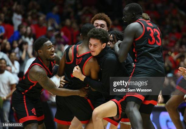 The San Diego State Aztecs surround Lamont Butler after he hit the game-winning 3-pointer against the New Mexico Lobos during the second half of...