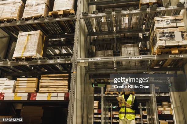 asian woman working using digital tablet in a warehouse - big data storage stock pictures, royalty-free photos & images