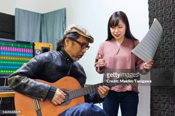 instructor and student during guitar lesson - makiko tanigawa stock-fotos und bilder