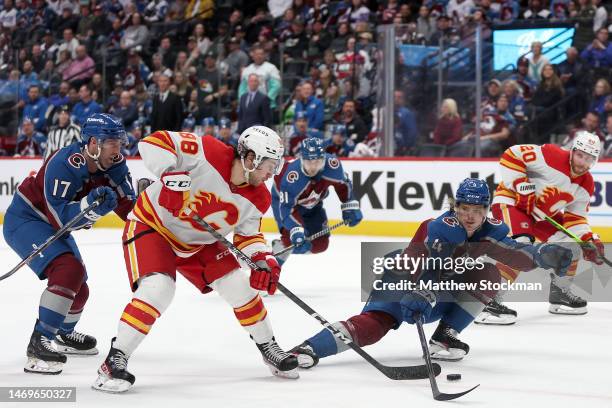 Andrew Mangiapane of the Calgary Flames advances the puck against Bowen Byram of the Colorado Avalanche in the third period at Ball Arena on February...