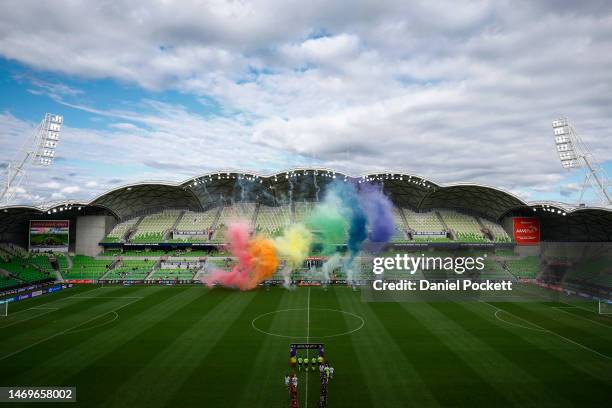 Players line up as rainbow coloured smoke is seen to support the 'pride cup' to start the round 15 A-League Women's match between Melbourne Victory...