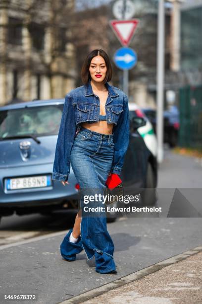 Tiffany Hsu wears a blue denim cropped oversized jacket, a blue denim V-neck / cropped top, a high waist blue denim long tube skirt, a black shiny...