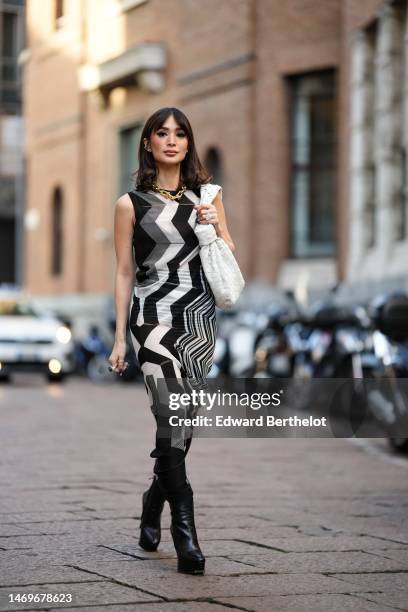 Heart Evangelista wears diamonds earrings, a gold large chain necklace from Tiffany, a black / white / gray wavy striped print pattern sleeveless...