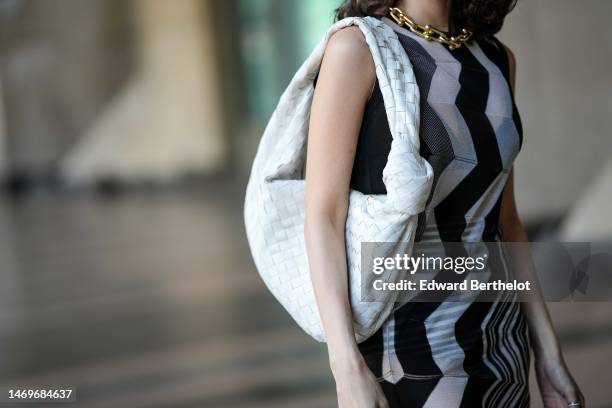 Heart Evangelista wears a gold large chain necklace from Tiffany, a black / white / gray wavy striped print pattern sleeveless long tube dress from...