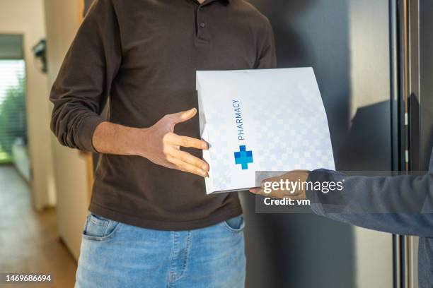 delivery worker giving order from drugstore - prescription home delivery stock pictures, royalty-free photos & images