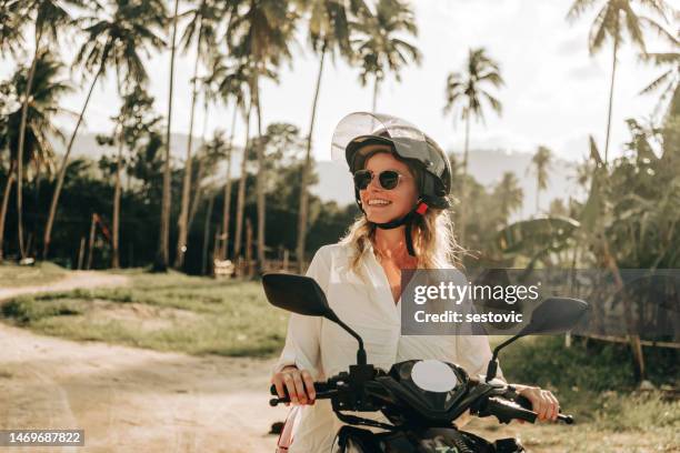 young woman riding a motorcycle on an island - thailand tourist stock pictures, royalty-free photos & images