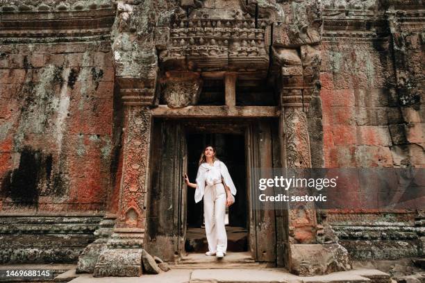 reisender, der die antiken ruinen des ta prohm-tempels in angkor erkundet - kambodscha stock-fotos und bilder