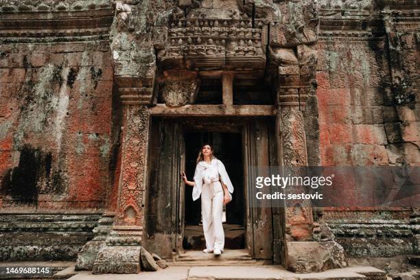 viaggiatore che esplora le antiche rovine del tempio di ta prohm ad angkor - angkor wat foto e immagini stock