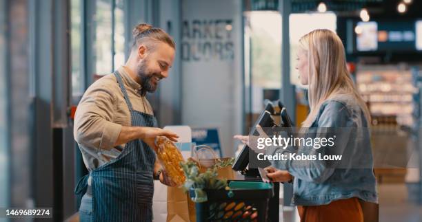 grocery store, food market payment and customer with supermarket employee at check out. retail discount, cash register and product promotion with a woman at a store counter paying for groceries - varuhus bildbanksfoton och bilder