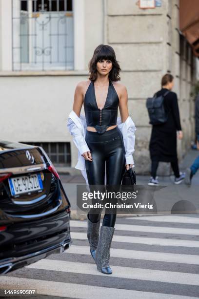 Justine Soranzo wears black leather top, high waisted leggings, glitter boots, white button shirt, Boyy bag outside Bally during the Milan Fashion...