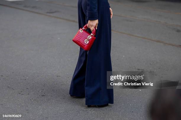 Guest wears red Dior bag outside Bally during the Milan Fashion Week Womenswear Fall/Winter 2023/2024 on February 25, 2023 in Milan, Italy.