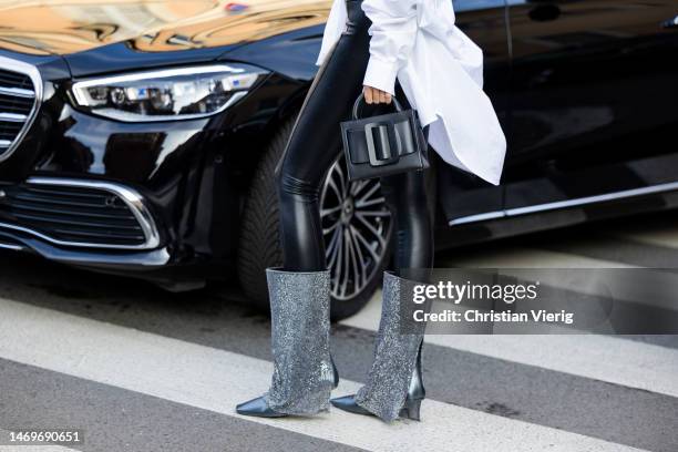 Justine Soranzo wears black high waisted leggings, glitter boots, white button shirt, Boyy bag outside Bally during the Milan Fashion Week Womenswear...