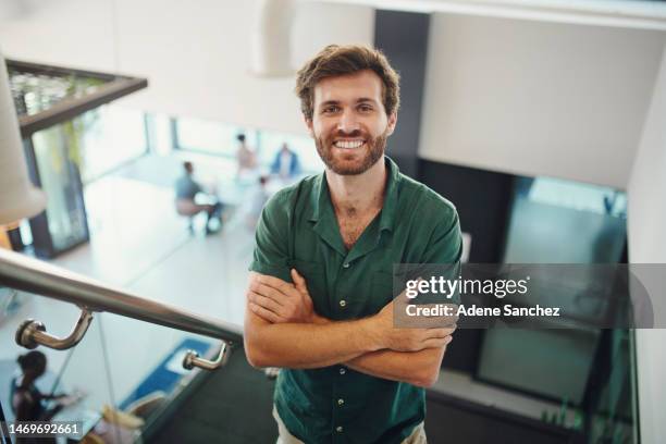 top view, portrait and business with man, arms crossed and smile on stairs, confident entrepreneur and modern office. startup, male leader and manager on steps, happiness and new project in workplace - portrait smile stockfoto's en -beelden