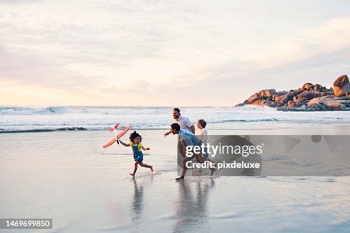 Happy family, running or flying toys on sunset beach or ocean in freedom holiday, energy bonding or travel playing fun. Sea, children or kids with airplane, interracial parents or aeroplane by nature Happy family, running or flying toys on sunset beach or ocean in freedom holiday, energy bonding or travel playing fun. Sea, children or kids with airplane, interracial parents or aeroplane by nature