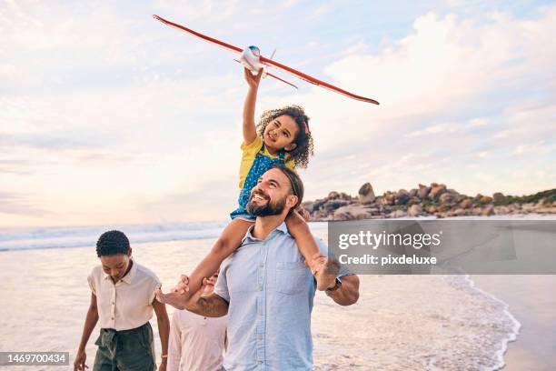 家族、ウォーキング、飛行機でサンセットビーチ、海、海での自由の休日、エネルギーの絆、ゲームをする。笑顔、幸せ、または空飛ぶおもちゃ、便乗、または異人種間の親を持つ子供 - family and happiness and diverse ストックフォトと画像