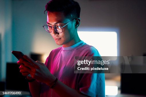 Asian man, phone or programming in night office of software development, cybersecurity review or database code safety. Programmer, developer or engineer on neon technology, web 3.0 coding or thinking Asian man, phone or programming in night office of software development, cybersecurity review or database code safety. Programmer, developer or engineer on neon technology, web 3.0 coding or thinking