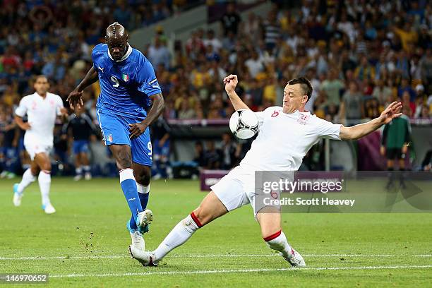 Mario Balotelli of Italy and John Terry of England challenge for the ball during the UEFA EURO 2012 quarter final match between England and Italy at...