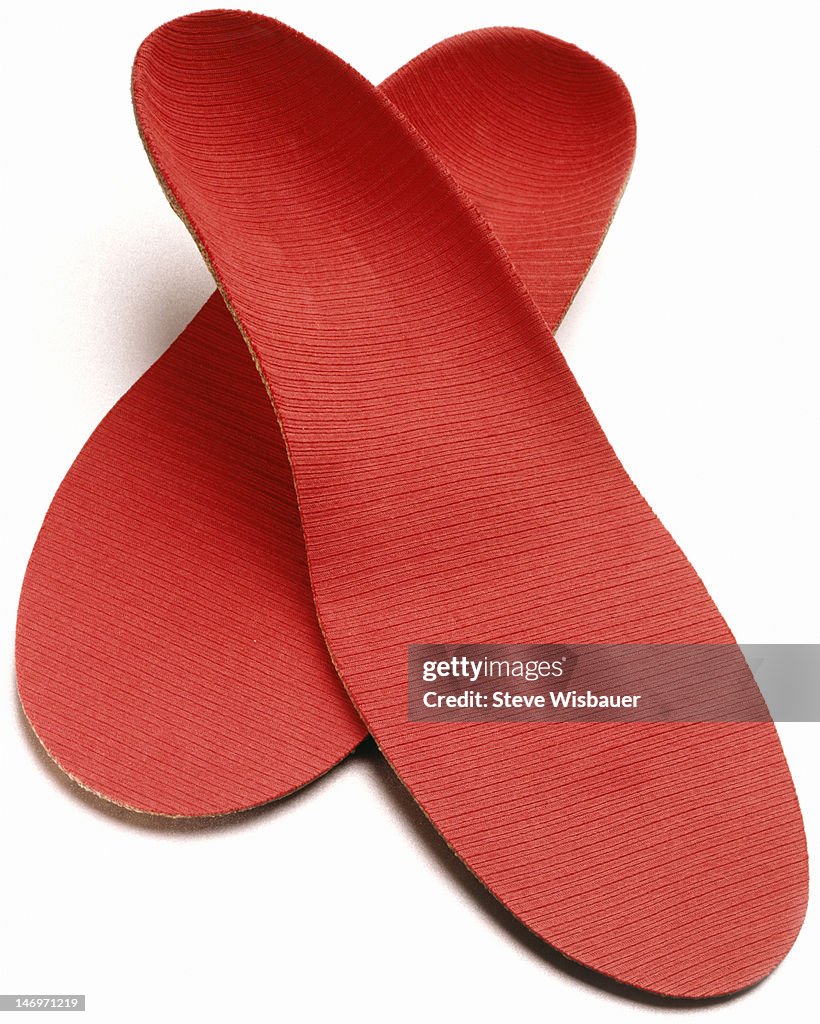 A pair of red orthopedic shoe insoles