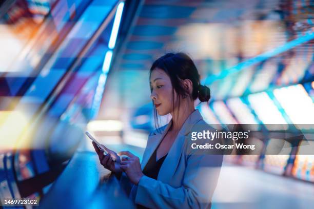 young asian business woman using smart phone in a virtual reality (vr) environment - finance technology stock-fotos und bilder