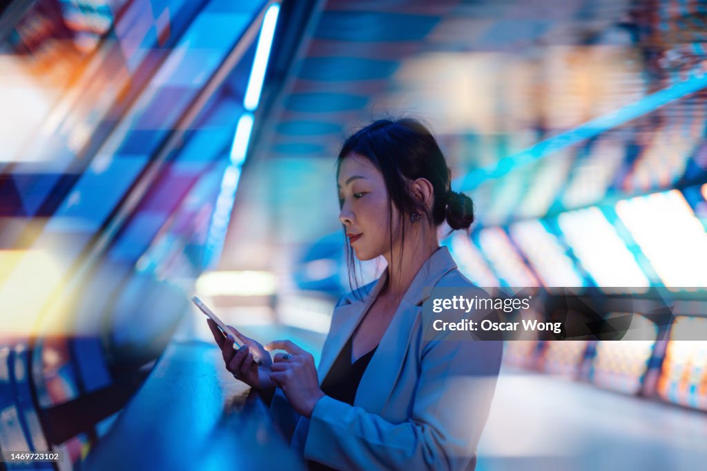 Young Asian business woman using smart phone in a Virtual Reality (VR) environment
