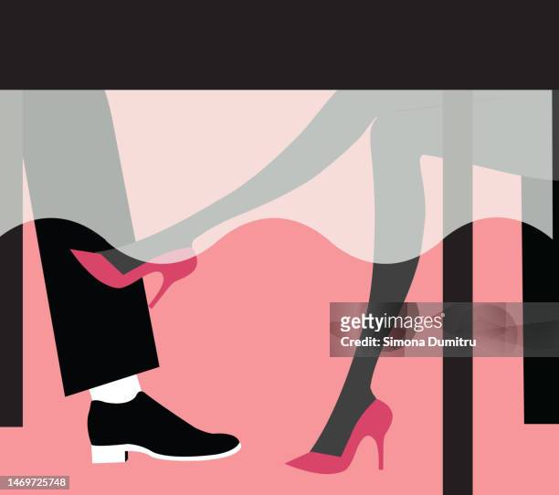 a woman flirting with a man with her feet  in a restaurant - flirten stockfoto's en -beelden