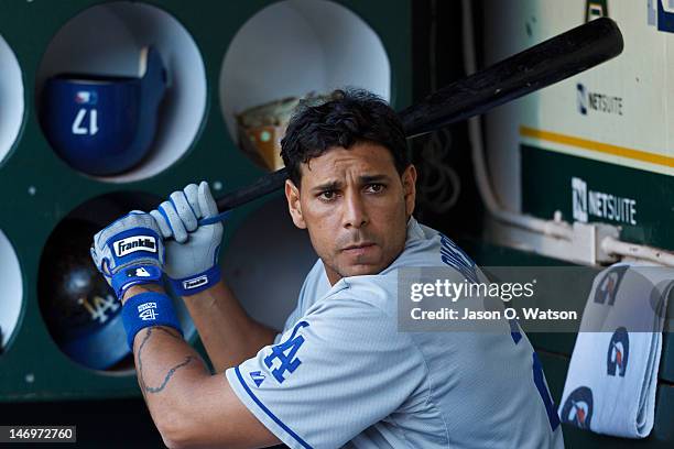 Juan Rivera of the Los Angeles Dodgers holds at bat in the dugout before an interleague game against the Oakland Athletics at O.co Coliseum on June...