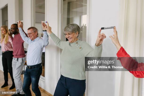 some office colleagues taking part in team building exercise - trust exercise stock pictures, royalty-free photos & images
