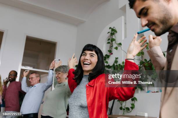 office workers smiling wile taking part in team building exercise - gender balance stock pictures, royalty-free photos & images