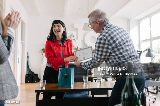 businesswoman receiving certificate at the office - prémio imagens e fotografias de stock