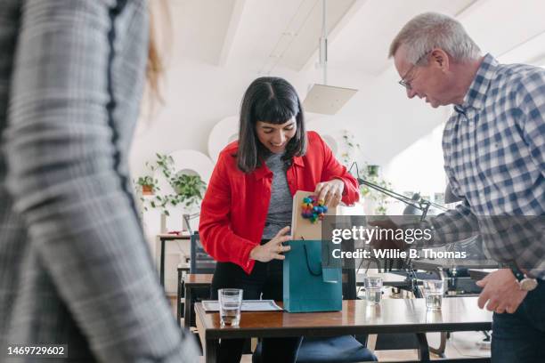 woman receiving gifts from colleagues at the office - handing over of office stock pictures, royalty-free photos & images