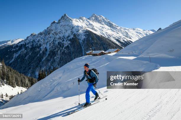 ski touring in front of snowcapped old huts in the mountains - montafon valley stock pictures, royalty-free photos & images