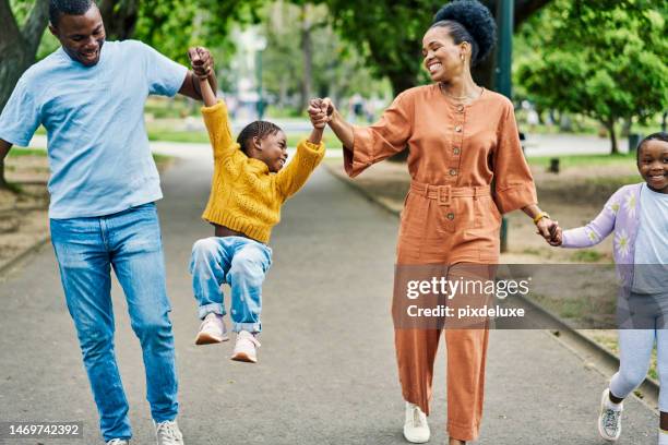 black family on walk in park with kids, holding hands and laughing together in nature on weekend. parents, happy children and love, man and woman with playful summer walking on garden path with smile - smile woman child stockfoto's en -beelden