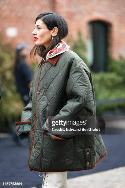 Gilda Ambrosio wears a khaki quilted oversized jacket from Gucci, a white with red print pattern silk scarf, white shiny leather laces front /...