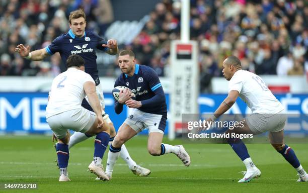 Finn Russell of Scotland runs with the ball while under pressure from Julien Marchand and Gael Fickou of France during the Six Nations Rugby match...