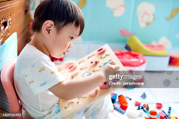 little boy playing with numbers toy puzzle - house puzzle stock pictures, royalty-free photos & images