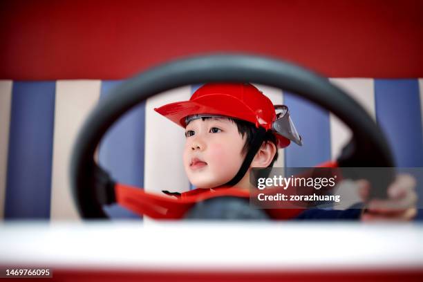 children imitation firefighter driving fire-truck - boy fireman costume stock pictures, royalty-free photos & images