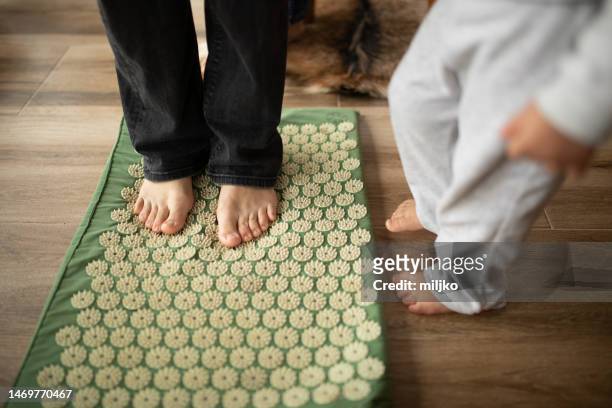 mother and daughter doing exercise against flat feet at home - pointed foot stock pictures, royalty-free photos & images