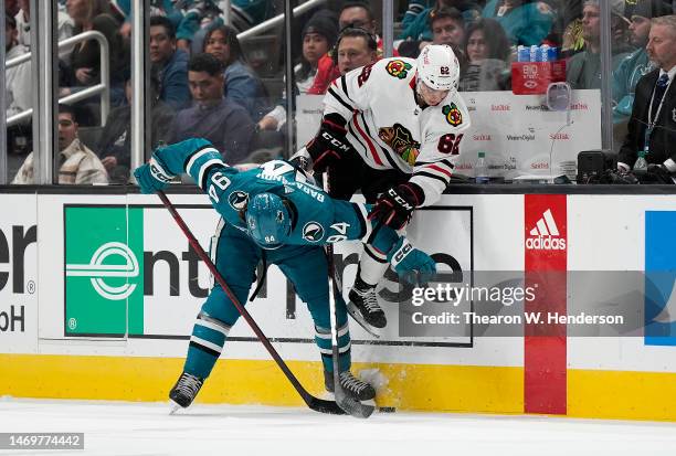Brett Seney of the Chicago Blackhawks to avoid a collision leaps over Alexander Barabanov of the San Jose Sharks during the third period at SAP...
