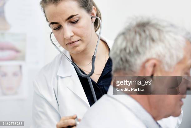 médico do sexo feminino fazendo check-up de saúde de paciente idoso do sexo masculino no hospital - sistema respiratório humano - fotografias e filmes do acervo