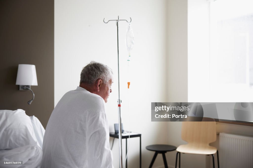 Sick senior patient sitting on hospital bed